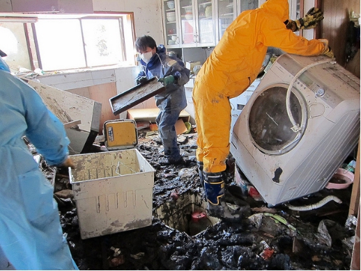 Odklízení sutin a nánosů v domě po zemětřesení v Japonsku 2011