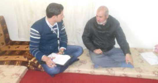 Riad Jaber Al-Nawawi talks with Caritas worker about his family needs.