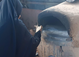 Nesreen postavila hliněnou pec a peče pro ostatní rodiny chleba